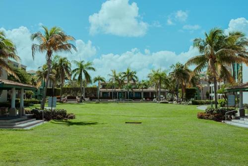 a park with palm trees in front of a building at Aquatika Paraíso Tropical in Loiza