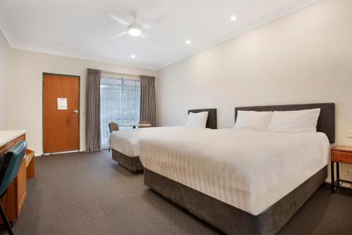a hotel room with two beds and a window at Manifold Motor Inn in Camperdown