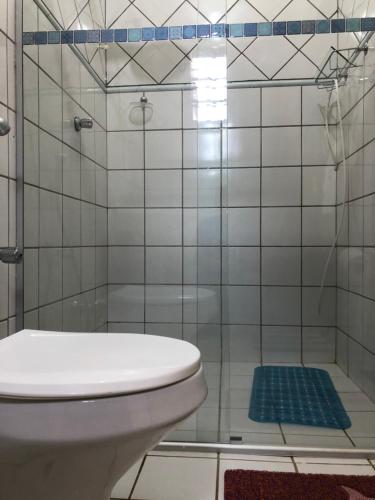 uma casa de banho com um WC e uma cabina de duche em vidro. em Chalé Pura Vida em São Roque de Minas