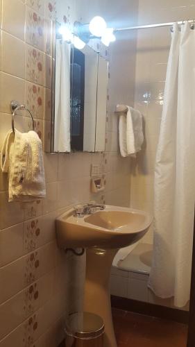 y baño con lavabo, aseo y espejo. en Posta del Ángel - Salta en Salta