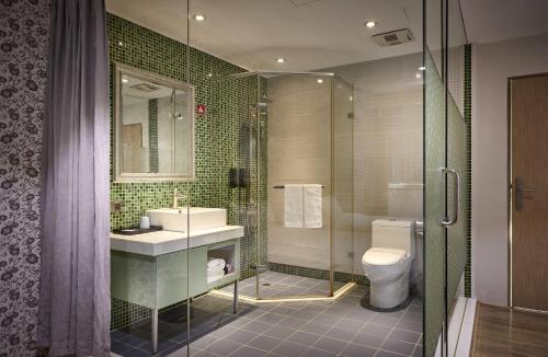a bathroom with a toilet and a sink and a shower at Oursea Hotel in Wuqi