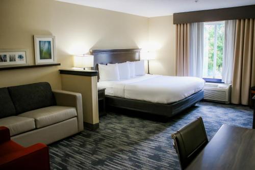 a hotel room with a bed and a couch at Country Inn & Suites by Radisson, Richmond West at I-64, VA in Richmond