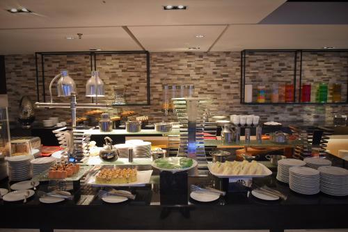 a buffet line with plates and food in a restaurant at UCSI Hotel Kuching in Kuching