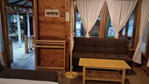 a living room with a couch and a table at Lazy Hut in Ko Phayam