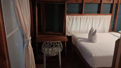 a bedroom with two beds and a mirror and a chair at Lazy Hut in Ko Phayam