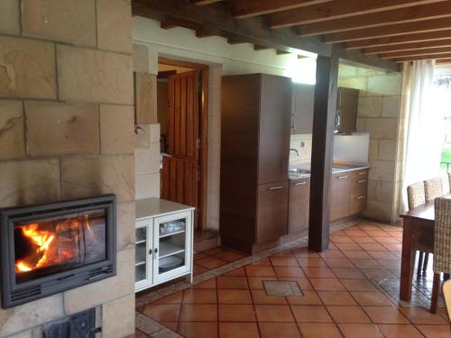 a kitchen with a fireplace and a stove at Casa Rural Alquitara in Ojedo