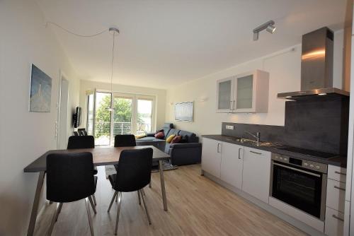 a kitchen and living room with a table and chairs at Meeresblick-Strandperle-Haus-2-WE-24 in Hohwacht