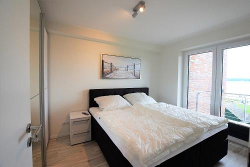 a bedroom with a large bed and a window at Meeresblick-Strandperle-Haus-2-WE-24 in Hohwacht