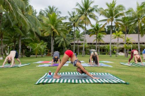 a group of people doing yoga in the grass at Bohol Beach Club in Panglao