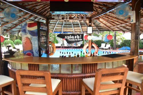 a bar at a resort with a pool in the background at Santana Beach Resort in Candolim