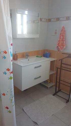 ein Badezimmer mit einem weißen Waschbecken und einem Spiegel in der Unterkunft SUPER SPACIEUX GÎTE PROCHE DE TOUTES COMMODITÉS in Saint-Just-Sauvage