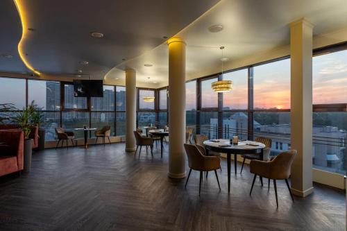 a restaurant with tables and chairs and a view of the city at Hotel Tura in Tyumen
