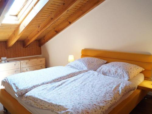 a bedroom with a bed with a wooden headboard and a window at Sehnsucht-Allgaeu in Oberstaufen