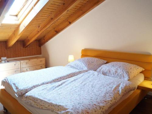 Schlafzimmer mit einem Bett mit einem Kopfteil aus Holz und einem Fenster in der Unterkunft Sehnsucht Allgäu in Oberstaufen