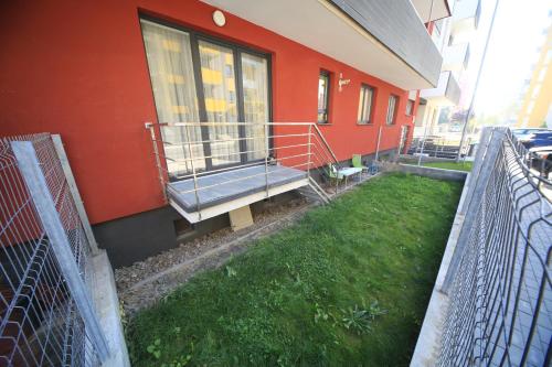 a building with a balcony and a grass yard at Happy Family in Braşov