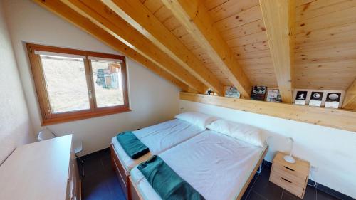 Monte Leone في بيلالب: غرفة نوم صغيرة مع سرير في منزل خشبي