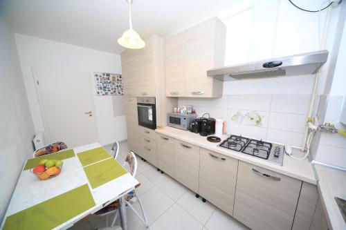 a kitchen with white cabinets and a table with fruit on it at Happy Family in Braşov