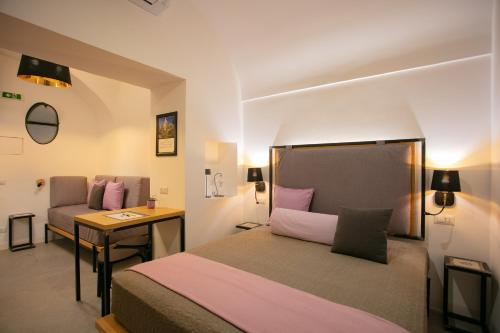 a bedroom with a bed and a desk and a table at Bellamania B&B in Anacapri