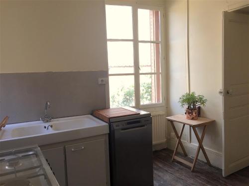 a small kitchen with a sink and a window at Maisons de Vignerons in Noyers