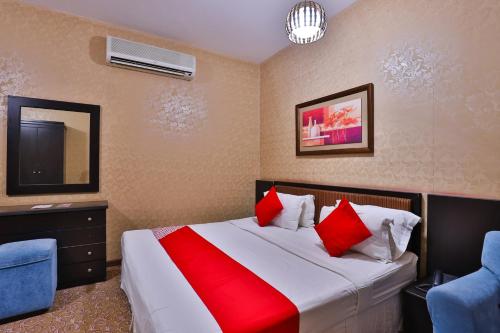 a hotel room with a bed with red pillows at Dome Al Sulaimaniah in Riyadh