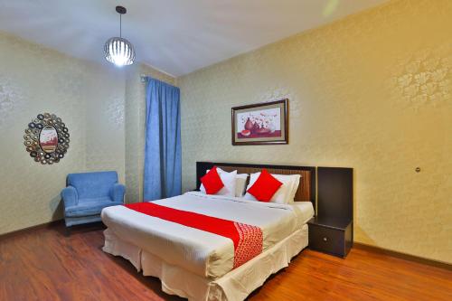 a bedroom with a large bed and a blue chair at Dome Al Sulaimaniah in Riyadh