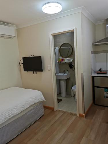 1 dormitorio con cama, lavabo y espejo en BHA unit 5 en Perth