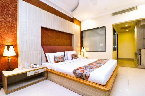 チャンディーガルにあるHotel Rajshree & Spaの大きなベッドとデスクが備わるホテルルームです。