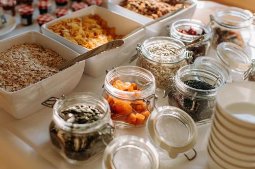 a table topped with jars of food and other foods at Gasthof Sunnebad in Sternenberg