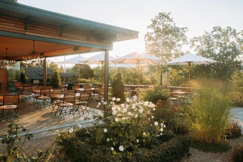 a patio with tables and chairs and umbrellas at Gasthof Sunnebad in Sternenberg