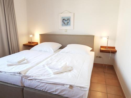 a large white bed with two white towels on it at Ferienwohnung 7 Katharina mit Balkon in Lauterbach