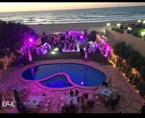 - un groupe de personnes autour d'une piscine sur la plage dans l'établissement North Coast Villa sea view with private pool, à Alexandrie