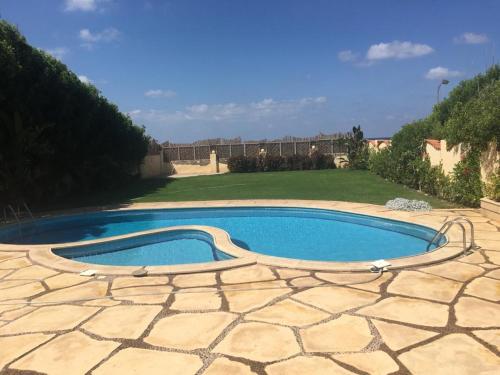 a small swimming pool in a patio with a yard at North Coast Villa sea view with private pool in Alexandria