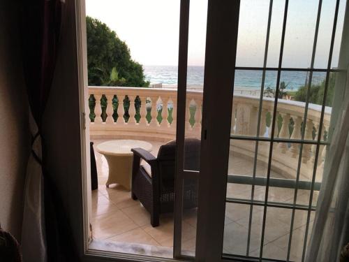Cette chambre dispose d'un balcon offrant une vue sur l'océan. dans l'établissement North Coast Villa sea view with private pool, à Alexandrie