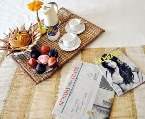 a table with a tray of food and a magazine at Hotel Sidharath in Shimla