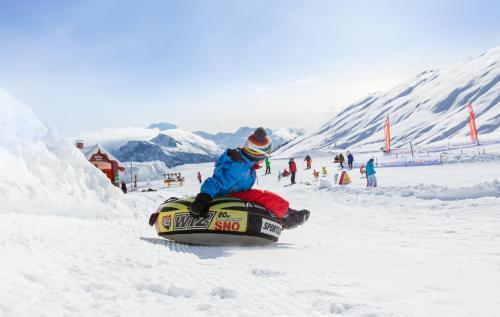 una persona está montando en una tabla de snowboard en la nieve en Vieux Valais VB en Blatten bei Naters