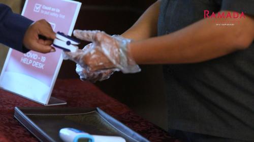a person holding a nintendo wii game controller at Ramada Plaza by Wyndham JHV Varanasi in Varanasi