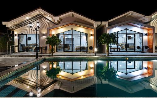a house with a swimming pool at night at Sandy Clay Bungalows in Sihanoukville