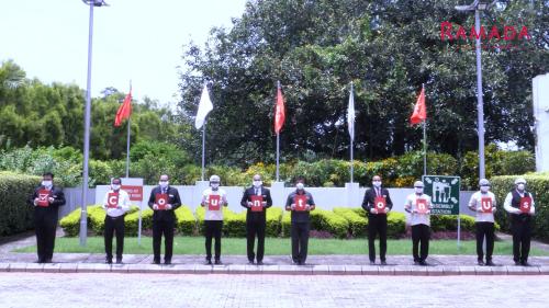 a group of men in uniform standing in front of flags at Ramada Plaza by Wyndham JHV Varanasi in Varanasi