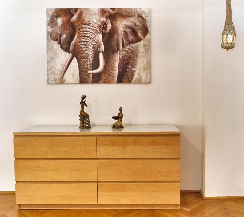 an elephant painting on a wall above a dresser at State Opera Alley Lodge in Vienna