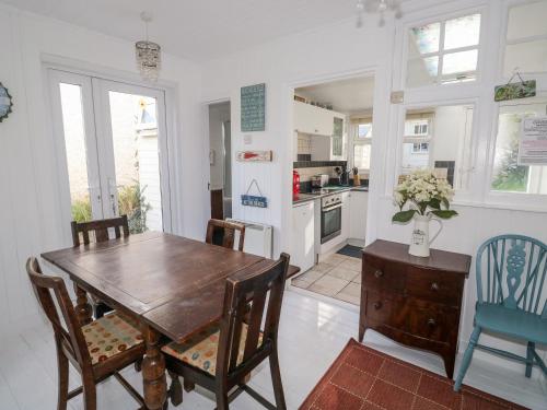 a kitchen and dining room with a wooden table and chairs at Driftwood in Wadebridge