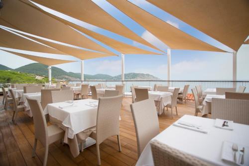 
a dining room table with chairs and umbrellas at Invisa Hotel Club Cala Blanca in Es Figueral Beach
