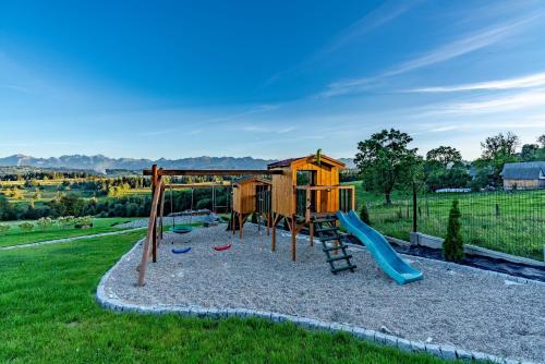 um parque infantil com um escorrega num campo em Góralska Dolina em Bańska