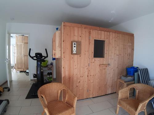 a large wooden door in a room with two chairs at Ferienwohnung Würzburg in Würzburg