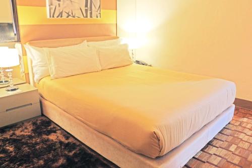
a bed with a white bedspread and pillows at Prince Plaza II Condotel in Manila
