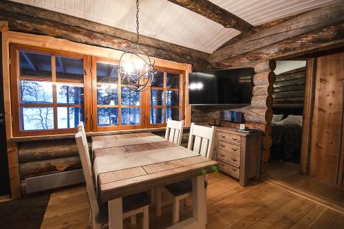 a dining room with a wooden table and a television at Kelokolo, Ivalo in Ivalo