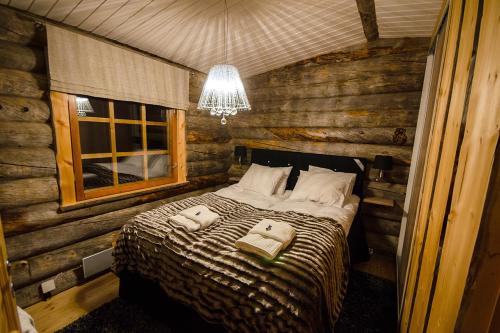 een slaapkamer met een bed met twee handdoeken erop bij Kelokolo, Ivalo in Ivalo