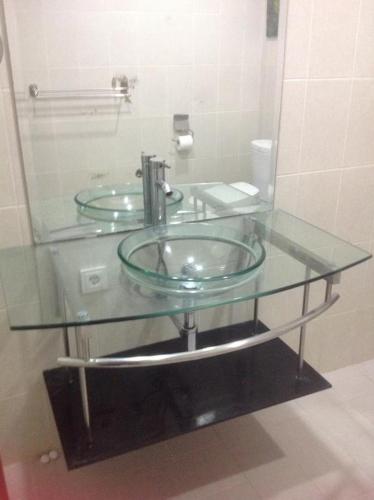a glass counter top with a sink in a bathroom at Bali Senia Hotel in Sanur