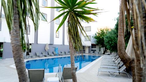 een zwembad met stoelen en palmbomen in een hotel bij Mert Seaside Hotel in Marmaris