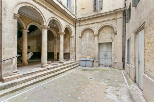 een lege binnenplaats van een oud gebouw met zuilen bij LGC Habitat - Studios Hyper Centre in Montpellier