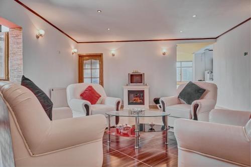 a living room with white chairs and a fireplace at Vila Magica in Constanţa